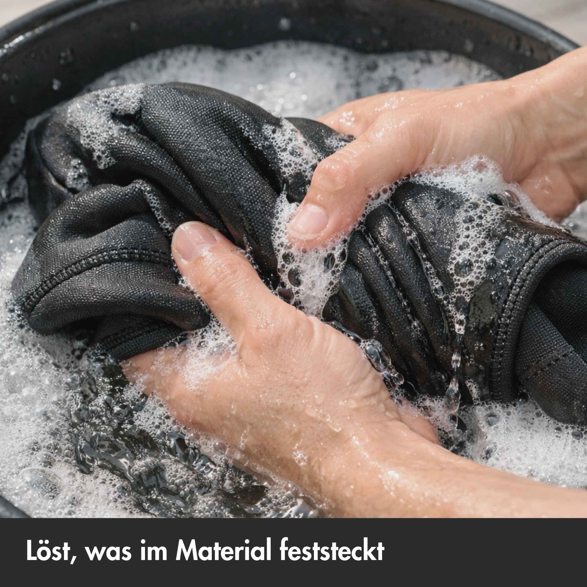 Neoprenanzug wird in Eimer per Hand gewaschen
