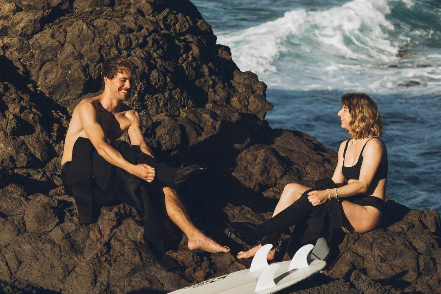 Surfer benutzen Surf Lube Neoprenanzug Anziehhilfe am Meer